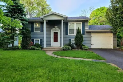 a blue house with a green lawn at Updated Home in the Heart of Saratoga Springs in Saratoga Springs