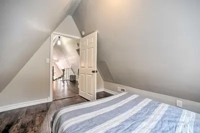 a bedroom with a bed and an open door at A-Frame Cabin with Hot Tub 5 Mi to Waterford! in Melrose