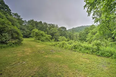 a dirt road in the middle of a forest at A-Frame Cabin with Hot Tub 5 Mi to Waterford! in Melrose