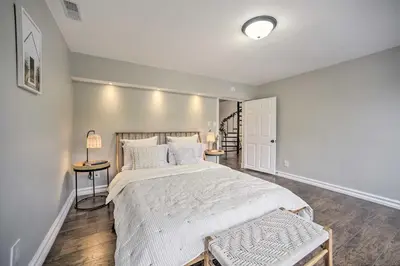 a bedroom with a large white bed and two tables at A-Frame Cabin with Hot Tub 5 Mi to Waterford! in Melrose