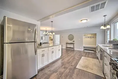a large kitchen with a stainless steel refrigerator at A-Frame Cabin with Hot Tub 5 Mi to Waterford! in Melrose
