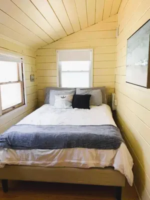 a bed in a small room with two windows at Cozy Beach - Direct Waterfront! in East Haven