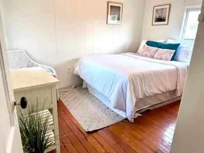 a bedroom with a bed with blue and pink pillows at Cozy Beach - Direct Waterfront! in East Haven