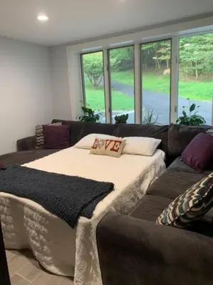 a living room with a large bed and a couch at The Suite at Pound Ridge in Pound Ridge