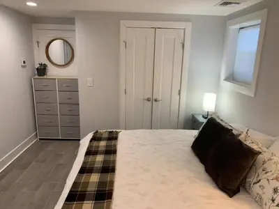 a bedroom with a bed and a dresser and a mirror at The Suite at Pound Ridge in Pound Ridge