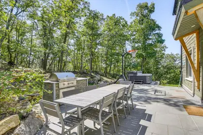 a patio with a table and chairs and a grill at The Glabin Garrison Gem with Hot Tub and Fire Pit in Garrison