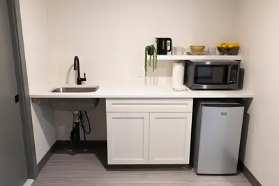 a kitchen with a counter with a microwave and a sink at East Rock Inn in Great Barrington