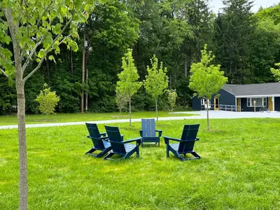 a group of chairs sitting in the grass at East Rock Inn in Great Barrington