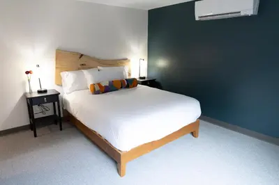 a bedroom with a large white bed with two tables at East Rock Inn in Great Barrington