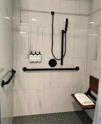 a bathroom with a shower with three bottles of soap at East Rock Inn in Great Barrington