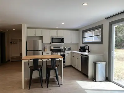 a kitchen with a table and two bar stools at East Rock Inn in Great Barrington