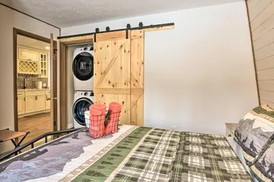 a bedroom with a bed and a washer and dryer at Tobyhanna Cabin with Deck, Community Pool and Golf! in Tobyhanna