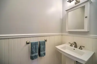 a white bathroom with a sink and a mirror at Stunning House with Deck, Game Room and Home Gym! in Saratoga Springs