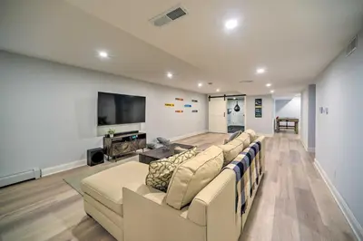 a living room with a couch and a flat screen tv at Stunning House with Deck, Game Room and Home Gym! in Saratoga Springs
