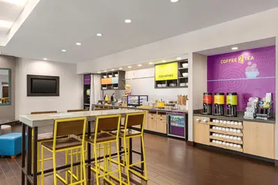 a store with yellow stools at a counter in a store at Home2 Suites Long Island City/Manhattan View in Queens