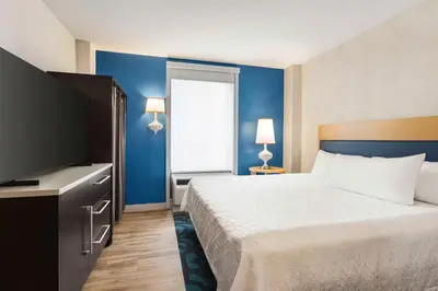 a hotel room with a bed and a flat screen tv at Home2 Suites Long Island City/Manhattan View in Queens