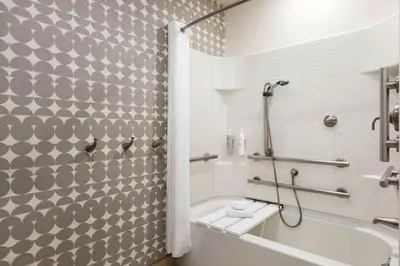 a bathroom with a shower and a tub and a toilet at Home2 Suites Long Island City/Manhattan View in Queens
