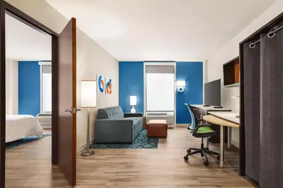 a hotel room with a bed and a desk with a desk at Home2 Suites Long Island City/Manhattan View in Queens