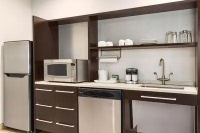 a kitchen with a refrigerator and a microwave at Home2 Suites Long Island City/Manhattan View in Queens