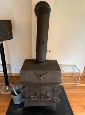 an old black stove sitting in a room at Harpersfield House /North West Catskills + sauna in Jefferson