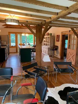 a living room with chairs and a table and a kitchen at Harpersfield House /North West Catskills + sauna in Jefferson