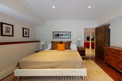 a bedroom with a large bed with an orange pillow at Sunny Day on Taunton Lake in Newtown