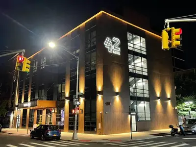 a building on a street at night with a traffic light at 42 Hotel Williamsburg in Brooklyn