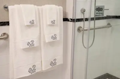 a bathroom with white towels in a shower at 42 Hotel Williamsburg in Brooklyn