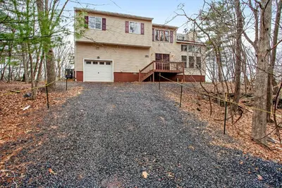 a house with a fence in front of it at Highland Hideaway in East Stroudsburg