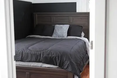 a bed with a wooden headboard in a bedroom at A Luxurious 5 star Location 2 QUEEN Bed’s TROY in Troy