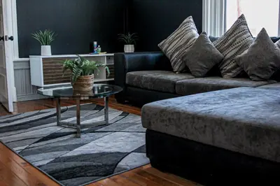 a living room with a couch and a table at A Luxurious 5 star Location 2 QUEEN Bed’s TROY in Troy