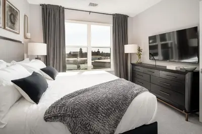 a bedroom with a large bed and a large window at Hyatus Luxury Residences City Crossing in New Haven