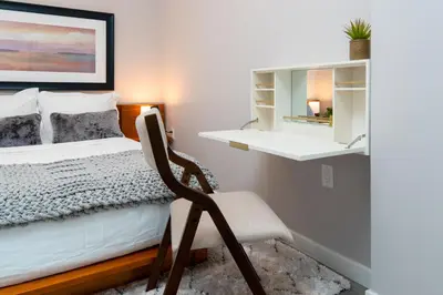 a bedroom with a bed and a chair in it at Hyatus Luxury Residences City Crossing in New Haven