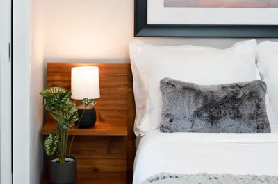 a bedroom with a white bed with a lamp on a table at Hyatus Luxury Residences City Crossing in New Haven
