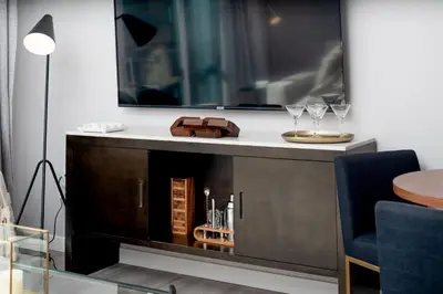 a living room with a table and a mirror at Hyatus Luxury Residences City Crossing in New Haven