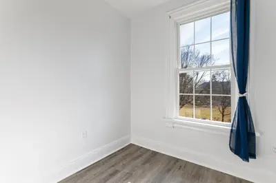 a white room with a window with blue curtains at Orange Oasis in the Heart of East Rock with FREE parking near DT and Yale in New Haven