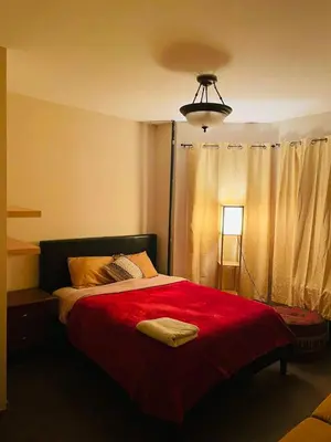 a bedroom with a red bed with a red blanket at MOTELCASA Guest House Newark NJ in Newark