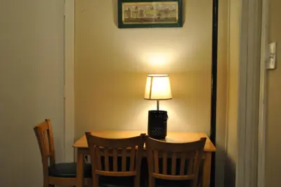 a table with chairs and a lamp on top of it at MOTELCASA Guest House Newark NJ in Newark
