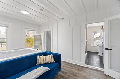 a blue couch in a white room with a tub at Cozy Gem in the Heart of East Rock with FREE Parking near Yale and DT in New Haven