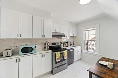 a kitchen with white cabinets and a stove top oven at Cozy Gem in the Heart of East Rock with FREE Parking near Yale and DT in New Haven