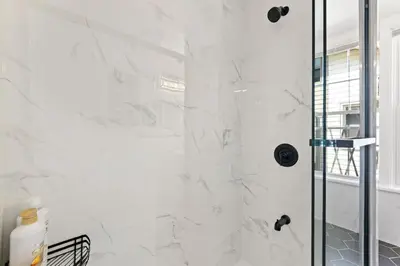 a white bathroom with a shower with a glass door at Casa Soleada in East Rock near DT and Yale SOM with FREE Parking and King Bed in New Haven