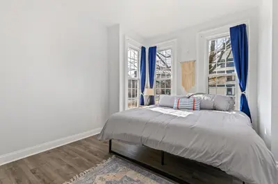 a white bedroom with a bed with blue curtains at Casa Soleada in East Rock near DT and Yale SOM with FREE Parking and King Bed in New Haven