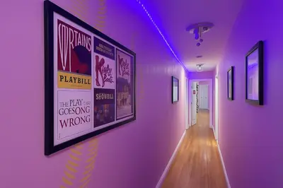 a hallway with a purple wall with posters on it at Lemon Vibes room in Guesthouse in New York