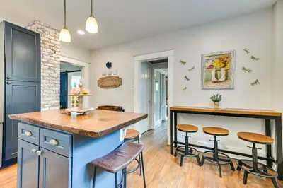 a kitchen with a blue island and stools at Family-Friendly Glens Falls Home with Sun Porch in Glens Falls