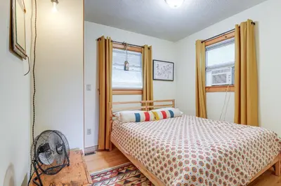 a bedroom with a bed and a window and a fan at Storybook Stratton House 3 Mi to Mount Snow! in Stratton