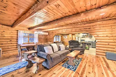 a living room with a couch and chairs in a log cabin at Spacious Cabin with Decks Near Saratoga Springs in Middle Grove
