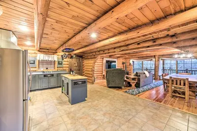 a kitchen and dining room in a log cabin at Spacious Cabin with Decks Near Saratoga Springs in Middle Grove