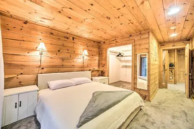 a bedroom with a bed and a wooden wall at Spacious Cabin with Decks Near Saratoga Springs in Middle Grove