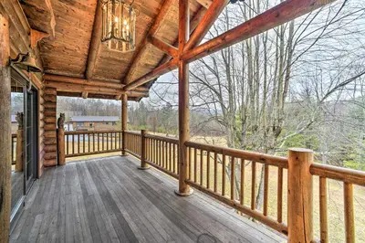 a porch of a wooden cabin with a chandelier at Spacious Cabin with Decks Near Saratoga Springs in Middle Grove
