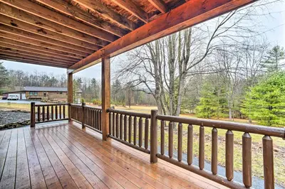a large porch with a wooden railing on a house at Spacious Cabin with Decks Near Saratoga Springs in Middle Grove